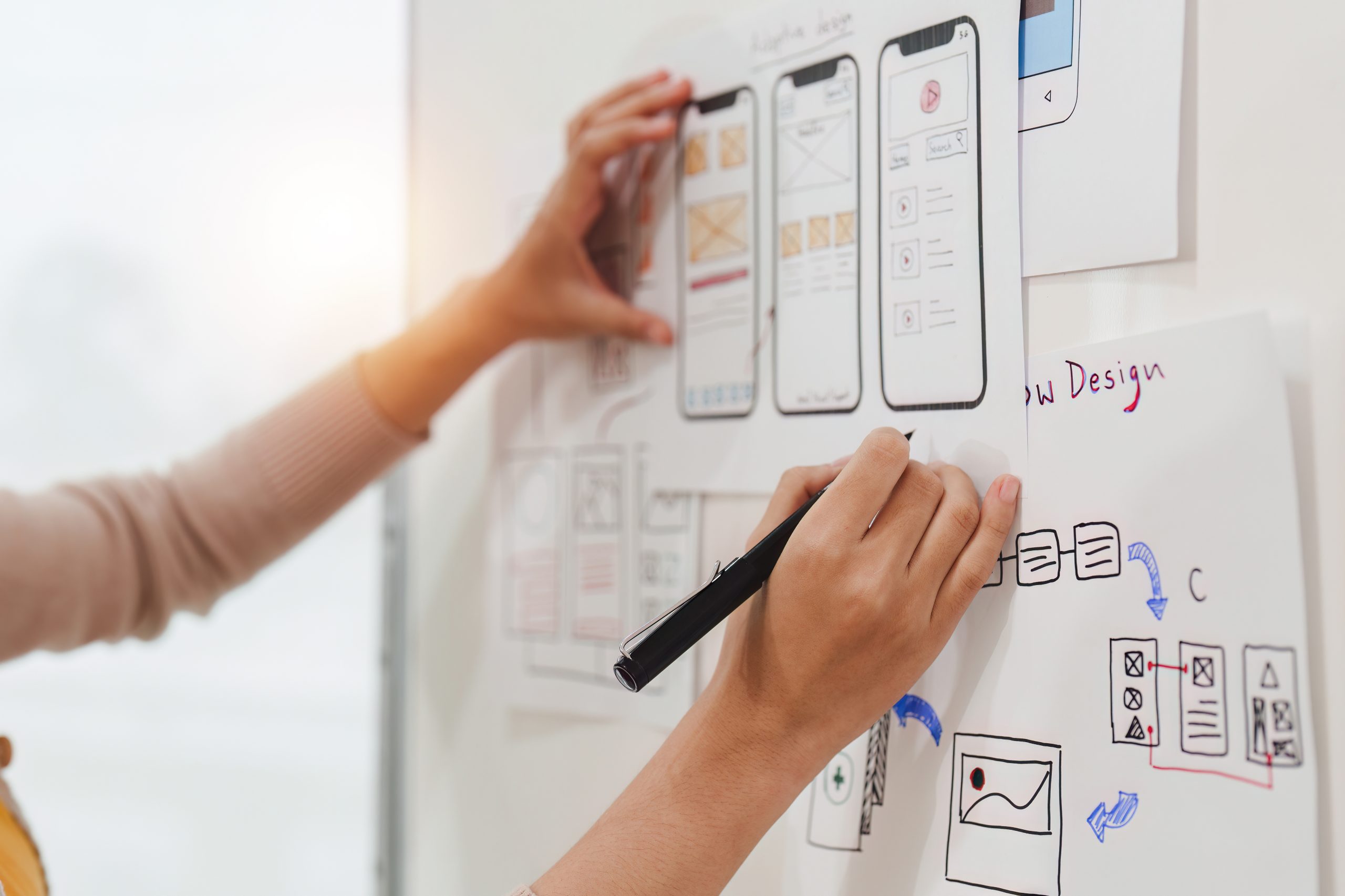 A developer working on a mobile application design with coding tools and a smartphone, symbolizing the mobile app development expertise at iVenzu Technologies.